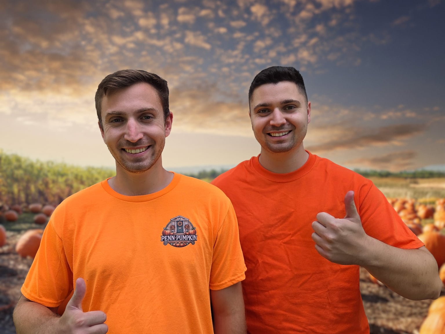 Brothers Daniel and Josh of Penn Pumpkin Co side by side in orange company shirts, both giving a thumbs up, with a field of pumpkins and an evening sky behind them